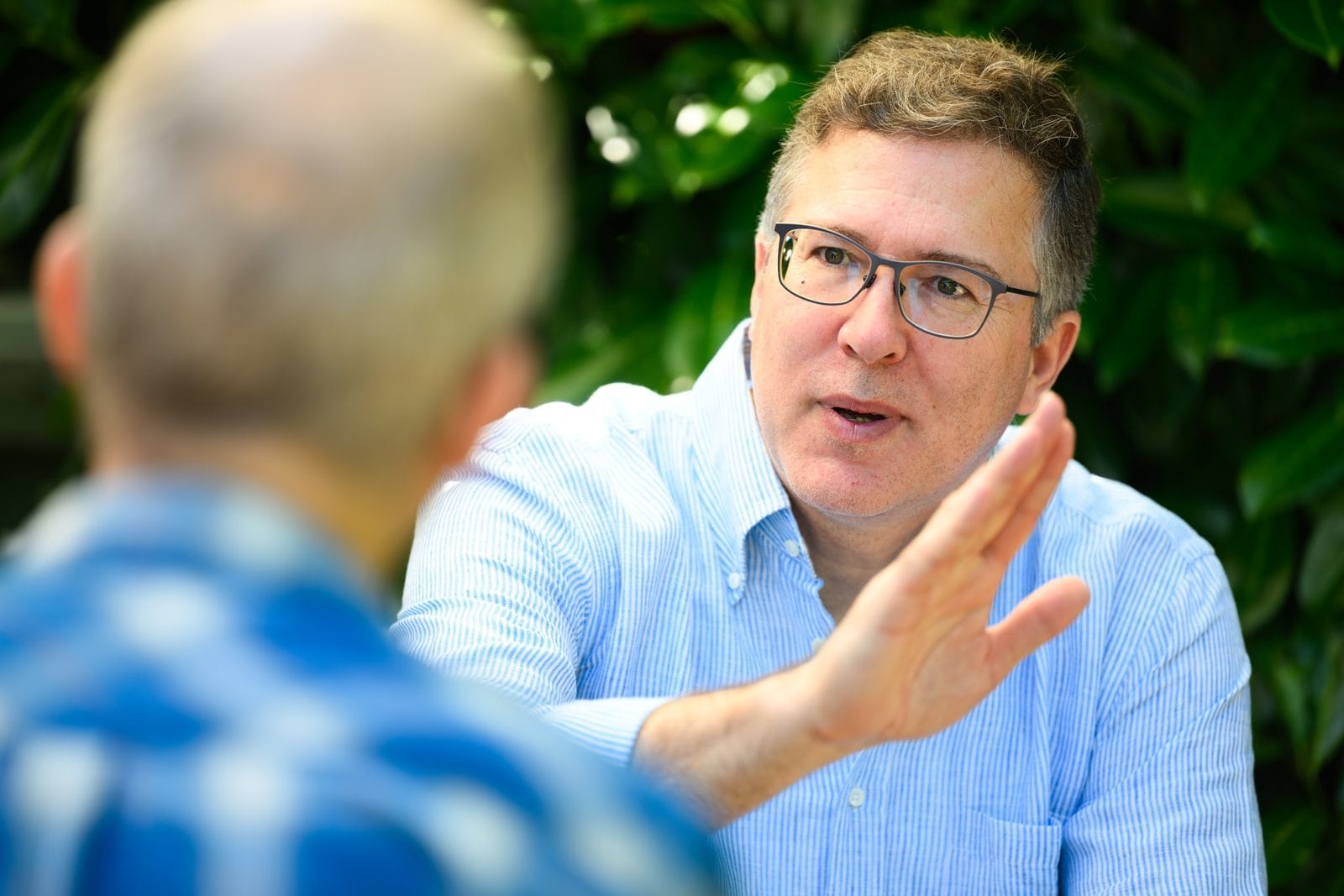 Teilnehmer erklärt im Team-Workshop seine Sicht, die Gruppe hört zu